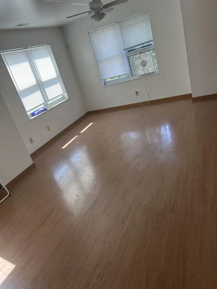 Bedroom before a Fresh Start cleaning in St. Louis, MO — hard floors and baseboards